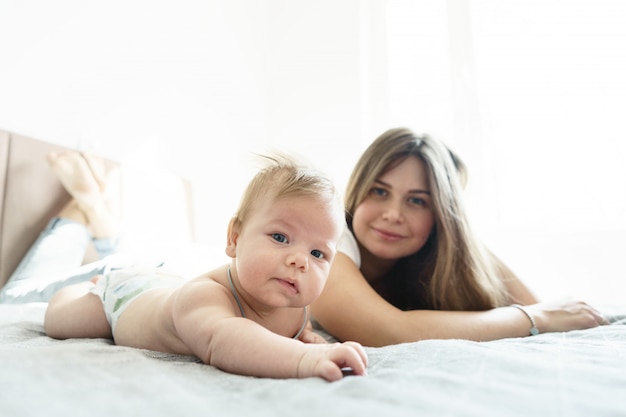 Moeder met haar pasgeboren zoon lag op het bed in de zonnestralen die uit het raam kwamen