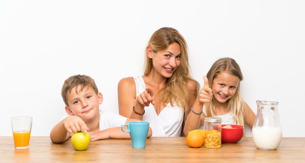 Moeder met haar twee kinderen aan het ontbijt en wijst naar voren