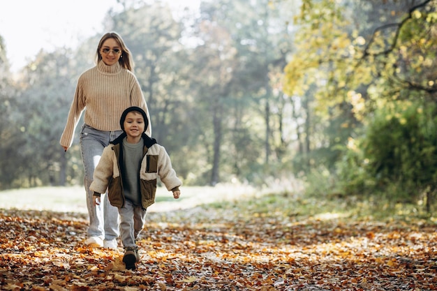 Moeder met haar zoontje wandelen in herfstpark