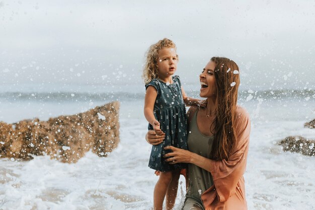 Moeder met jonge dochter op een strand