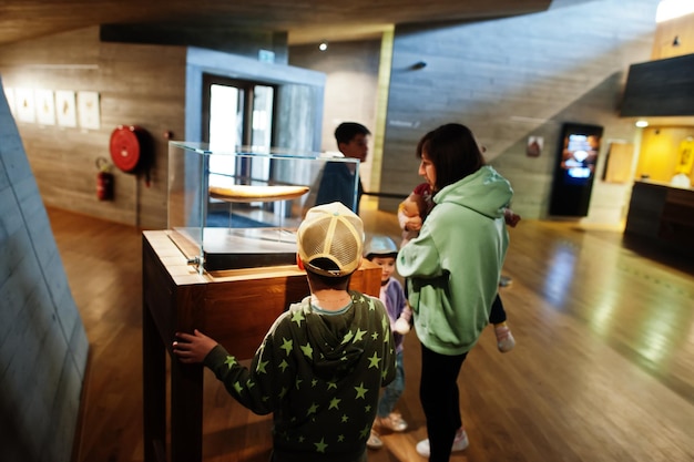 Moeder met kinderen die exposities in museumzalen verkennen