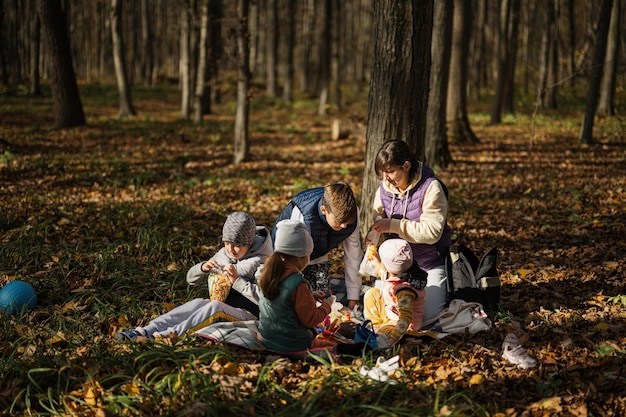 Moeder met kinderen in familiepicknick in het herfstbos