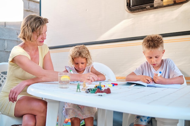 Moeder met kinderen in haar caravan bij camping schilderij