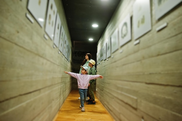 Moeder met kinderen op ontdekkingstocht door exposities in museumzalen