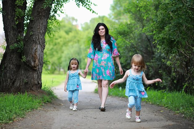 Moeder met twee dochters tweeling voor een wandeling in het park