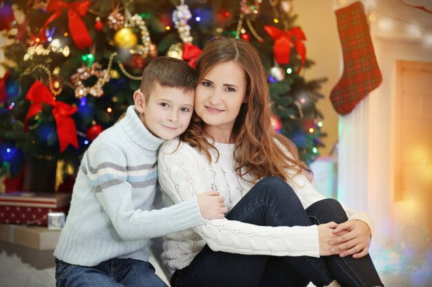 Moeder met zoon bij kerstboom