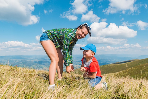 Moeder met zoon bovenop berg prachtig landschapsmening reizen wandelconcept