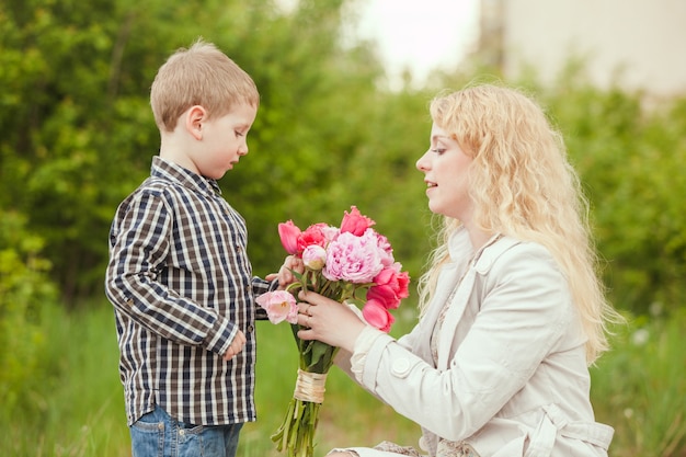 Moeder met zoon en bloemen voor moederdag