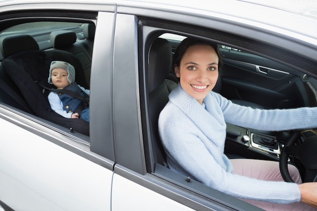 Moeder rijdt met haar baby in de autostoel