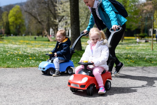 Moeder rolt haar kinderen op een speelgoedauto