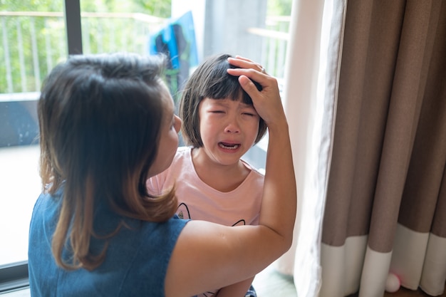 Moeder sloeg haar kind, kinderen huilden, verdrietig, jong meisje ongelukkig, concept van gezinsgeweld, selectieve focus en zachte focus