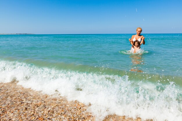 Moeder speelt in het water met haar dochter