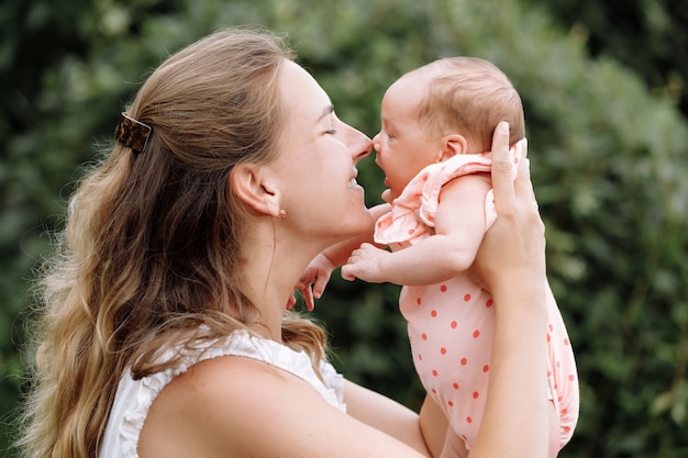 Moeder speelt met haar babymeisje buiten op zomerdag