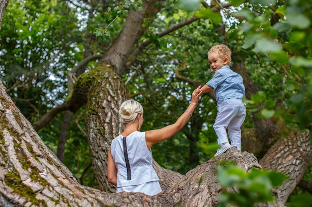 Moeder speelt met haar kind op boom in het park.