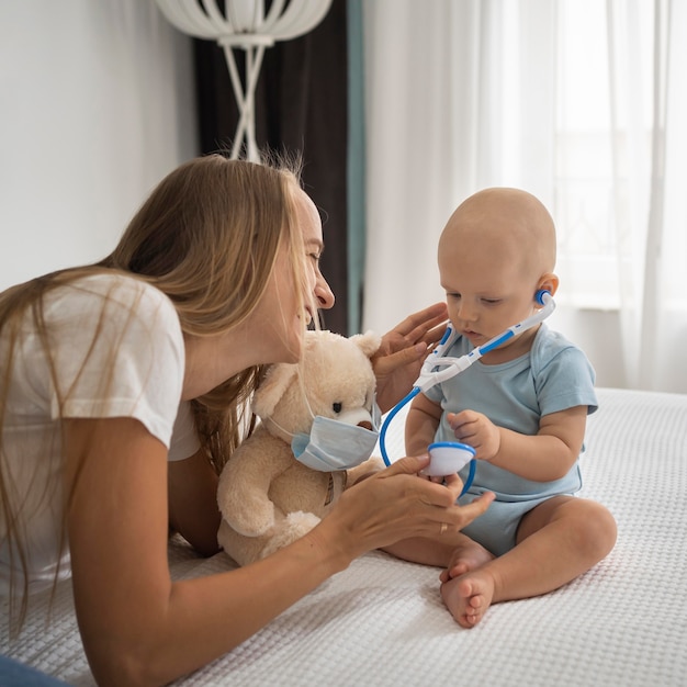 Foto moeder spelen met kind met teddybeer medische masker dragen