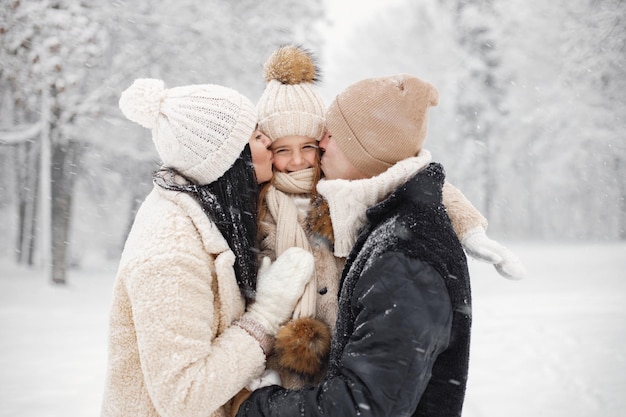 Moeder vader en hun dochtertje spelen buiten op winterdag