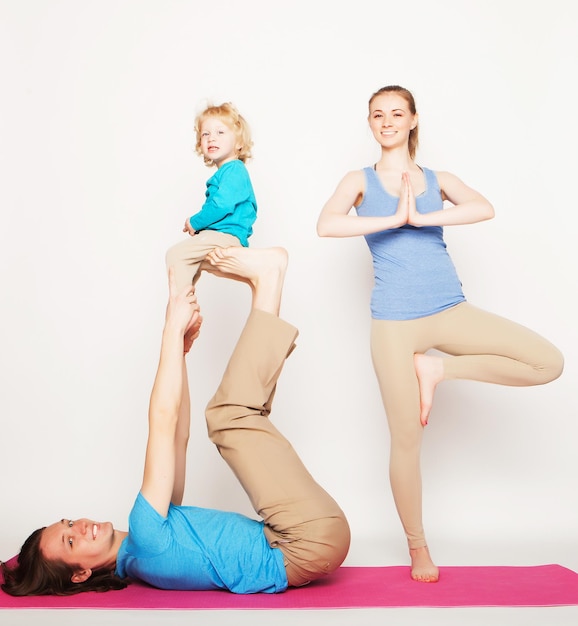 Moeder, vader en zoon doen yoga op witte achtergrond