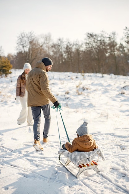 Moeder vader en zoontje tijd samen doorbrengen op winterdag op een slee