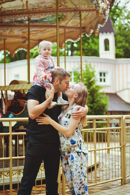 Moeder, vader, meisje wandelen in de stad, groen park. lachen op zonnige dag. Plezier hebben. Familie