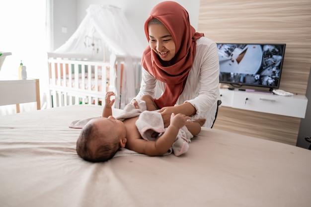 Moeder veegt haar babyjongen af met een handdoek