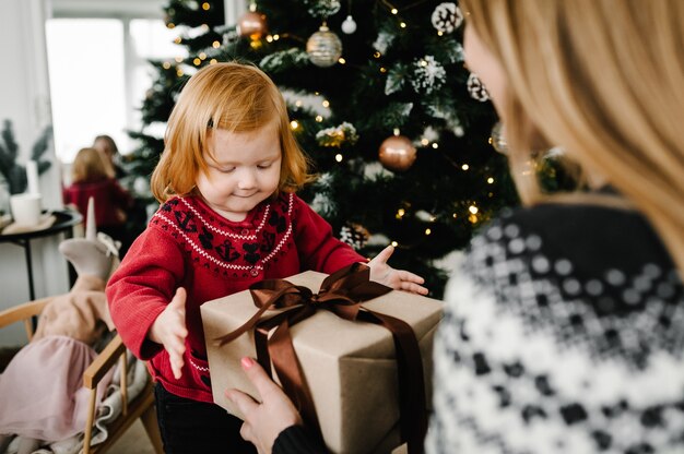 Moeder verrast zijn kind met een kerstcadeau Familie open geschenkdoos