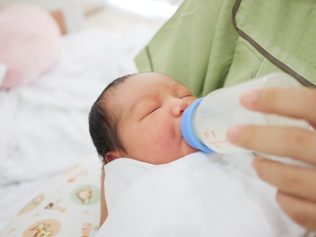 Moeder voedt haar pasgeboren baby uit een fles