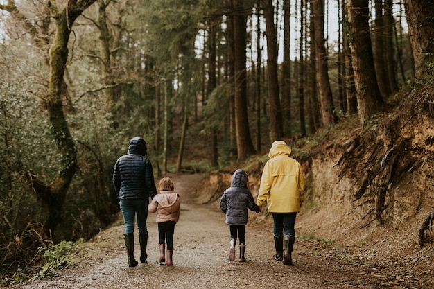 Moeder wandelen met haar dochters in het bos achteraanzicht