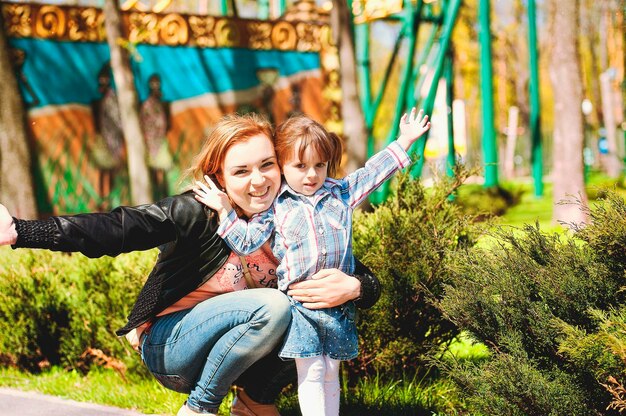 Moeder, zoon spelen in de speeltuin, lachend tijdens een zomerwandeling. zonnige dag. Vakantie met het gezin. Kinderen