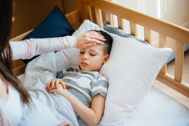 moeder zorgt voor haar kind dat koorts heeft. Ziekte en gezondheidszorg