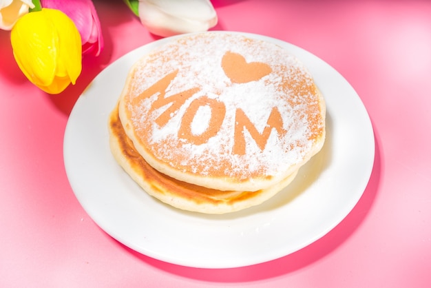 Moederdag brunch restaurant uitnodiging concept. verschillende moms womans day menu-achtergrond, met traditioneel ontbijt en lunch eten en drinken, met bloemen op zonnige roze achtergrond