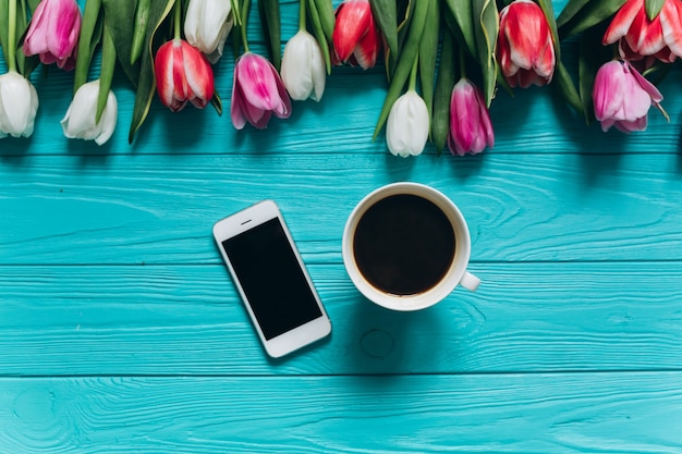 Moeders dag concept. Tulpen, koffie en smartphone.