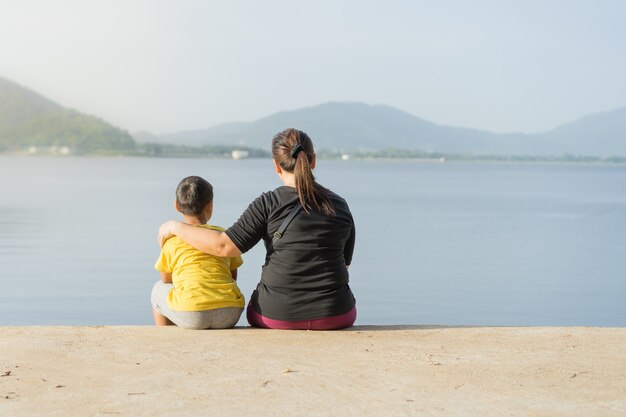 Moeders en kinderen zitten in het Bang Phra-reservoir in de zonsondergang