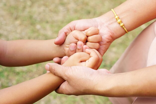 Moeders hand met de hand van een klein meisje op bokeh achtergrond Liefde en familie concept