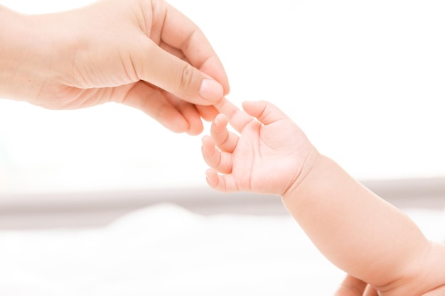 Moeders hand met pasgeboren baby's op blote voeten