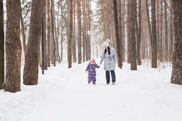 Moederschap, kinderen en natuur concept - Aantrekkelijke jonge vrouw en schattig kind wandelen in het park