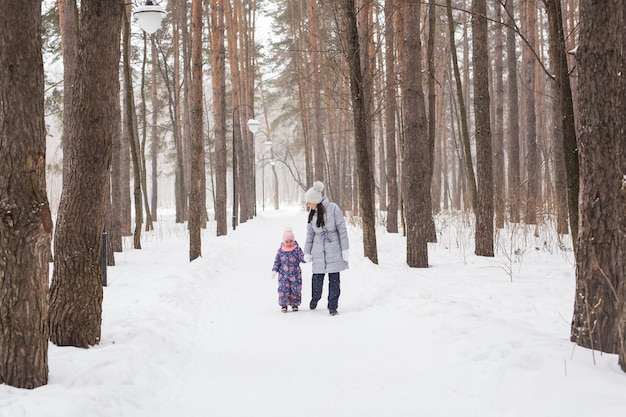Moederschap, kinderen en natuur concept - Aantrekkelijke jonge vrouw en schattig kind wandelen in het park