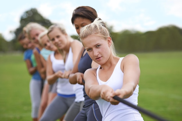 Moge de beste vrouw winnen Shot van een groep jonge vrouwen die verwikkeld zijn in touwtrekken