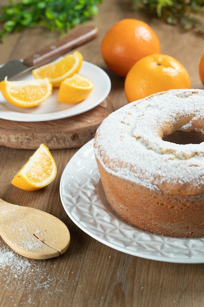 Moist orange fruit cake on plate with orange slices on wooden table Delicious breakfast traditional English tea time Orange cake recipe