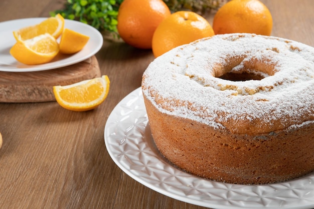 Moist orange fruit cake on plate with orange slices on wooden table Delicious breakfast traditional English tea time Orange cake recipe