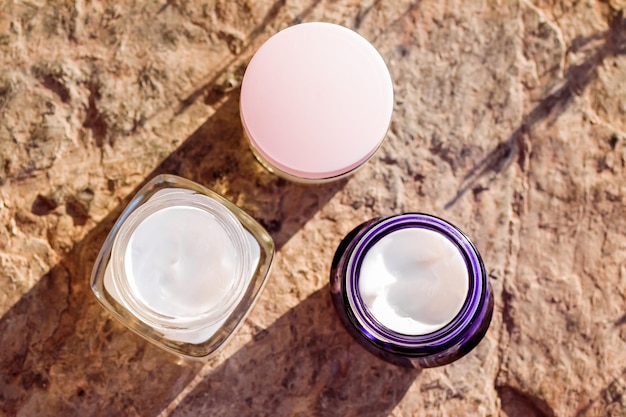 保湿美容クリームは、夏の日没の化粧品とスキンケアで石の背景にスキンケアとスパ化粧品を瓶詰めします