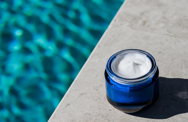 Moisturising beauty cream skincare and spa cosmetics by swimming pool in summer cosmetic product and skin care