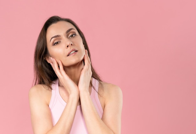 Idratare il viso bella donna senza trucco in piedi con le mani sui suoi pulcini massaggiandolo ...