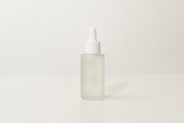 写真 白い背景のスタジオパッキングとスキンケアの美しさの概念上の保湿クリームボトル