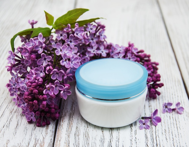 Moisturizing cream and lilac flowers