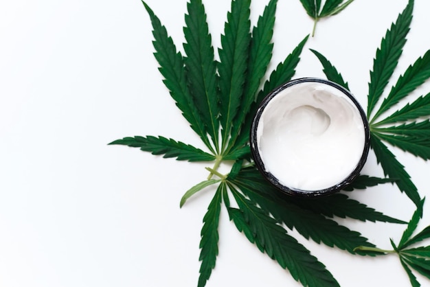 Crema idratante con olio di canapa su sfondo bianco con spazio per la copia l'uso della cannabis nella produzione di cosmetici per la cura della pelle