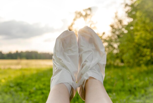Moisturizing foot mask for dry heels feet. woman wearing one time moisturizing foot mask socks.