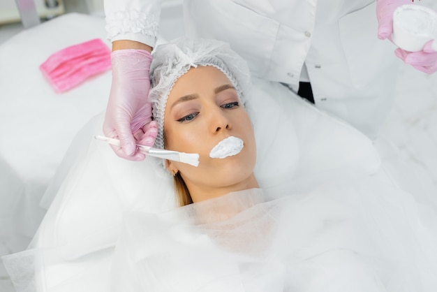 Moisturizing the lips during a cosmetic procedure for a young woman