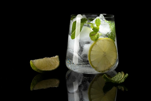 Mojito cocktail on a black background with reflection