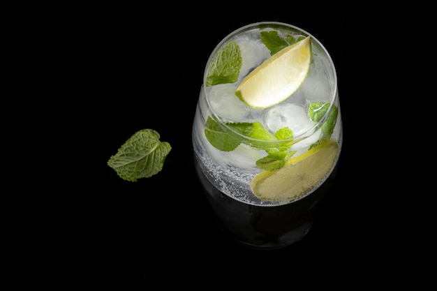 Mojito cocktail on a black background with reflection