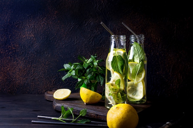 Mojito cocktail in glass, lemons and mint leaves